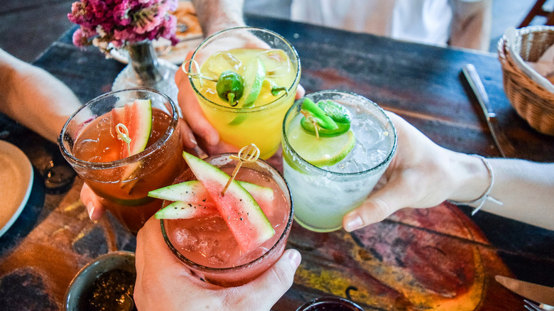 hands toasting mixed drinks