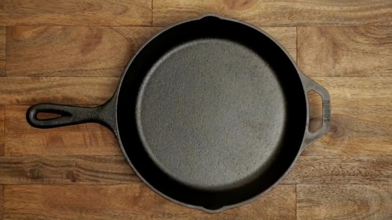 A cast-iron skillet on a wooden table.