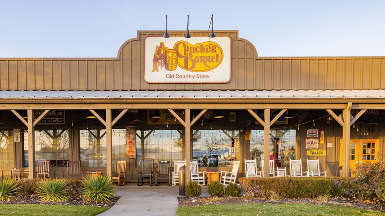Exterior of Cracker Barrel restaurant with rocking chairs outside.