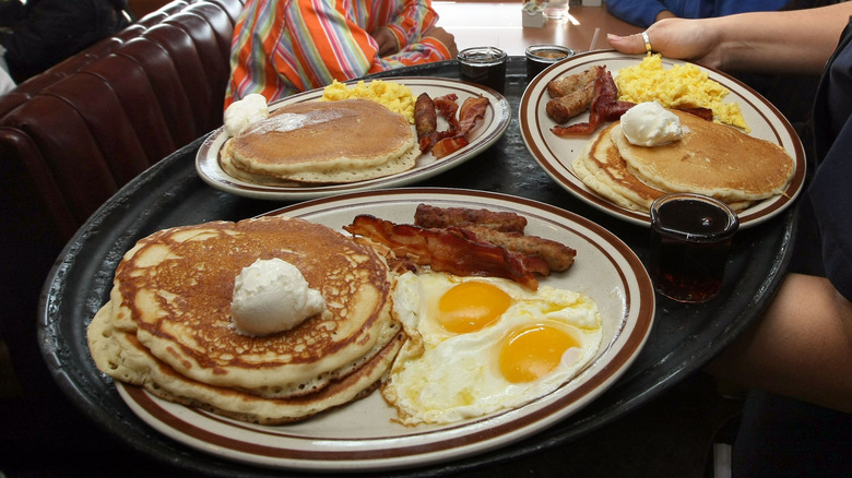 Denny's signature Grand Slam breakfast with pancakes, eggs, bacon, and sausage.