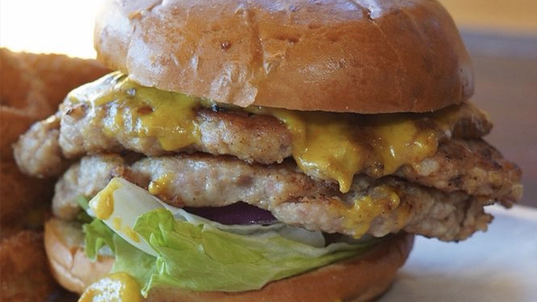 closeup of burger with alligator patties and curry sauce