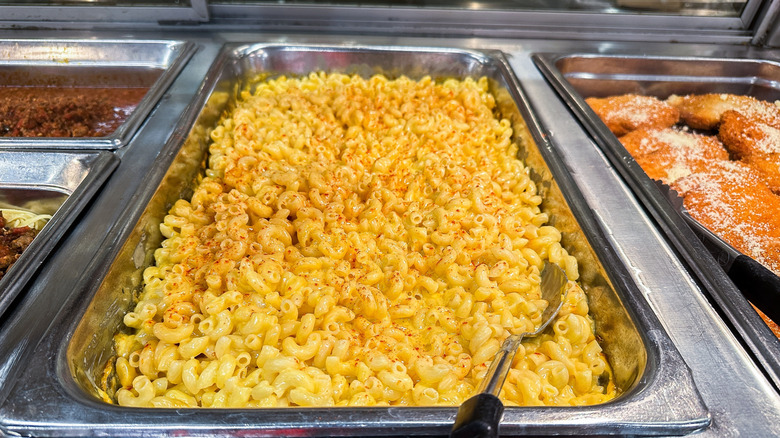 a buffet line with a hotel pan of macaroni and cheese.