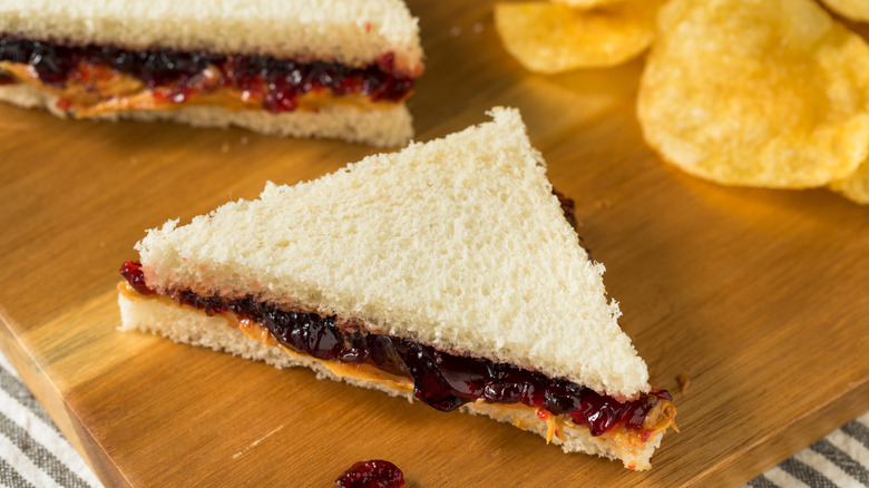 a crustless triangle sandwich of peanut butter and grape jelly on white bread