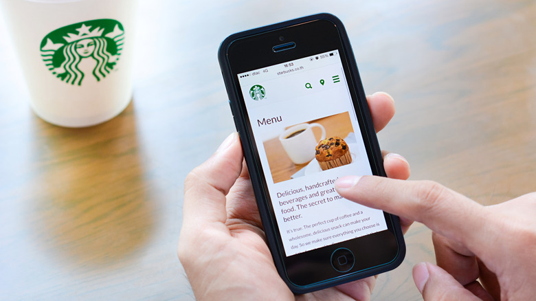 person navigating Starbucks site on smartphone