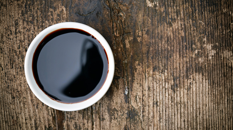 Bowl of balsamic vinegar on wooden table