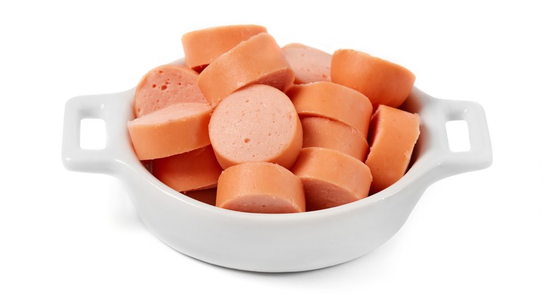 Slices of hotdog in white bowl
