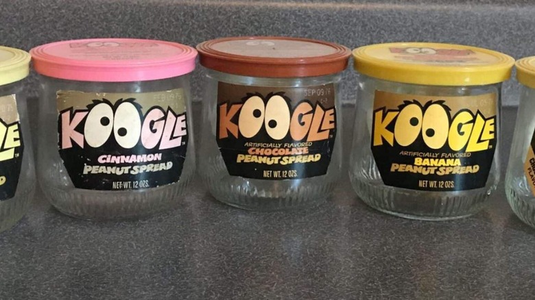 A line of empty Koogle jars for multiple flavors, laid out on a dark-colored counter