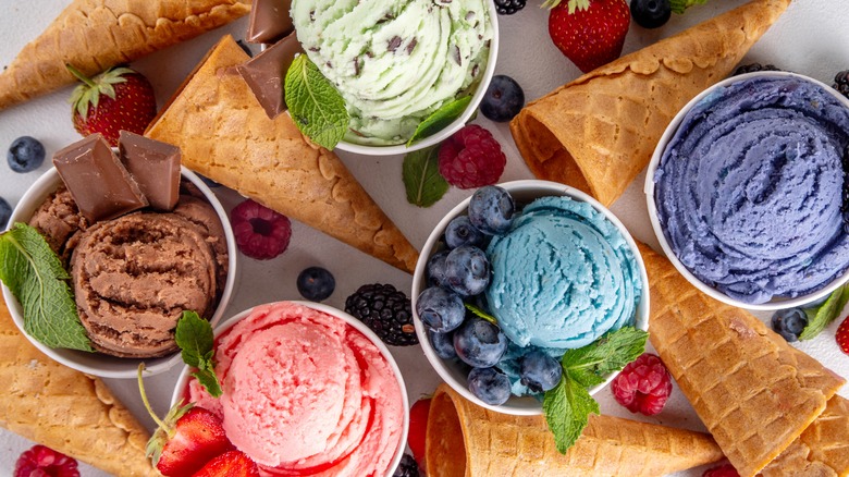 Overhead view of dishes full of various colorful ice creams and cones