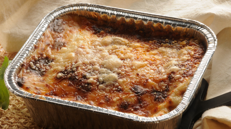 A frozen lasagna in a metal tray after being baked in the oven.