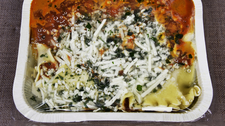 Closeup of a frozen lasagna still in the packaging.