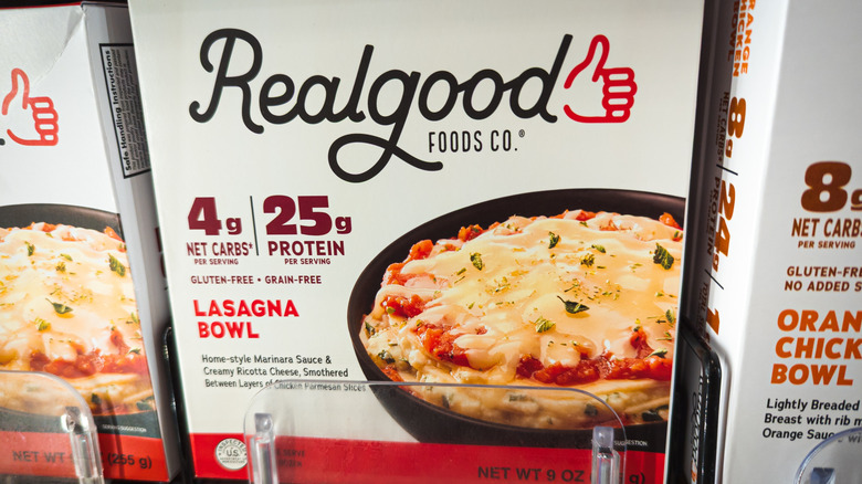 Real Good Foods lasagna bowl in the freezer section of a grocery store.