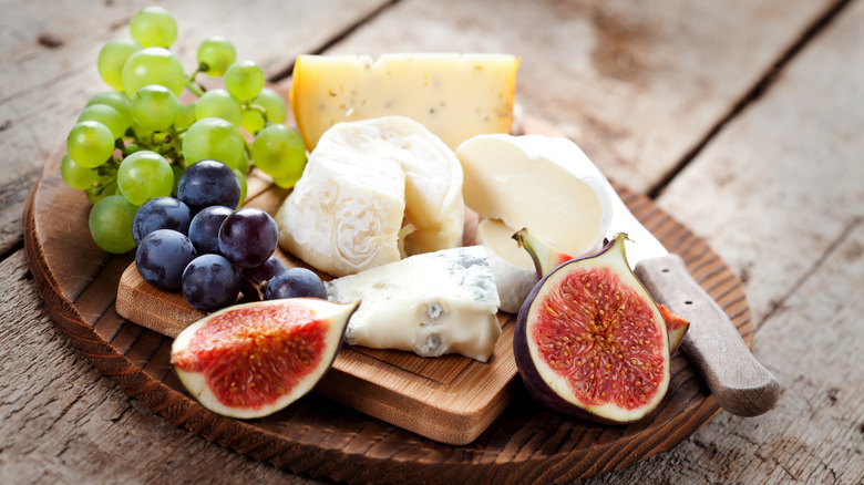 A platter of cheeses and fruit.