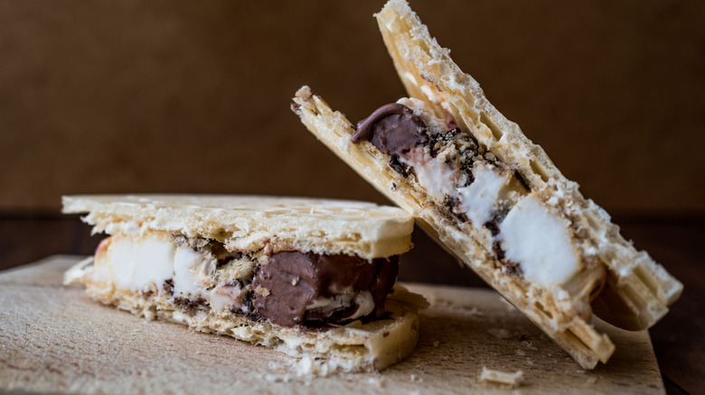 one piece of a frozen chocolate and cream dessert sandwich leaning on another piece