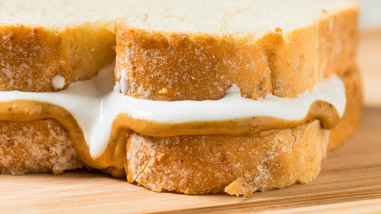 closeup of a sandwich with white bread, marshmallow fluff, and peanut butter