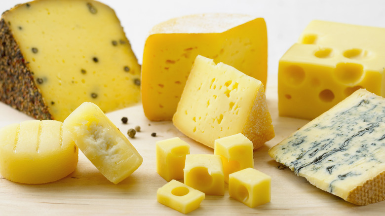 Assorted cheeses on wooden board