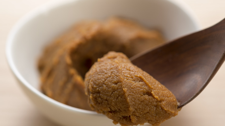 miso paste on wooden spoon, blurred background