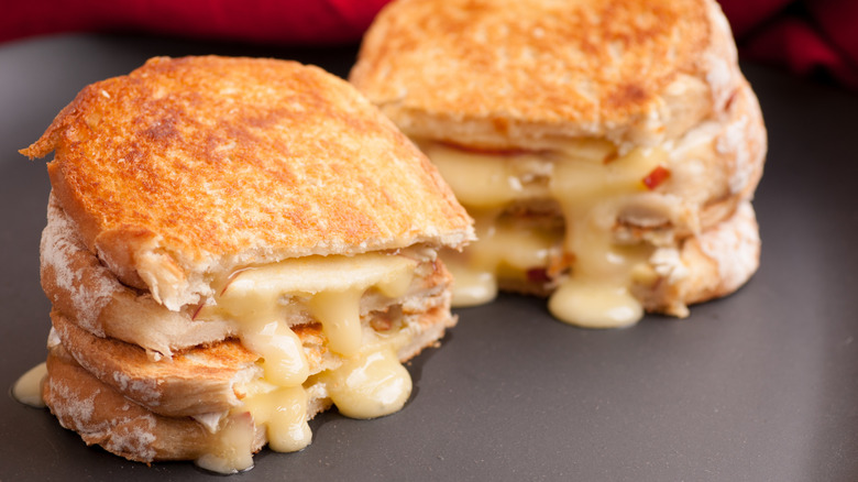 Cheesy Raclette sandwiches with sliced apples on a grey plate