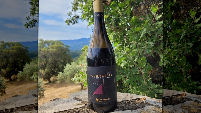 A bottle of Agiorgitiko wine on a rock ledge outdoors