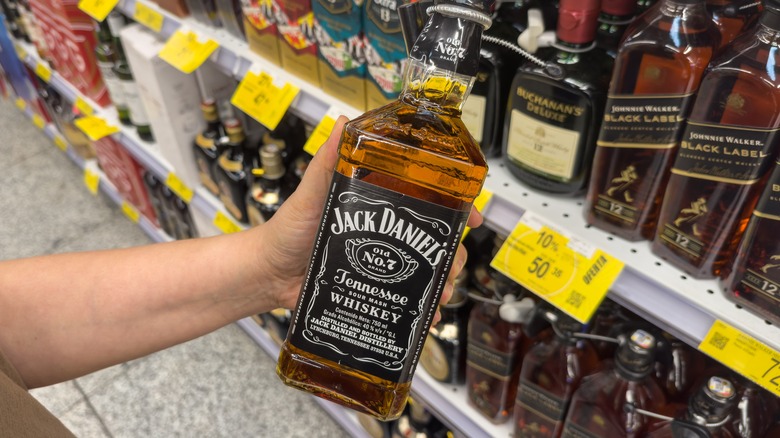 Hand selecting bottle of Jack Daniels whiskey
