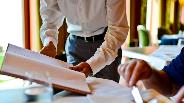 server reviewing menu with diner
