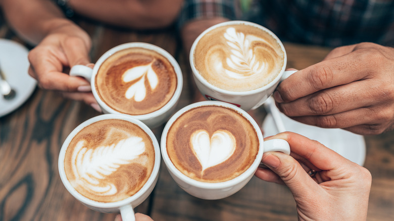 Four lattes with steamed milk designs