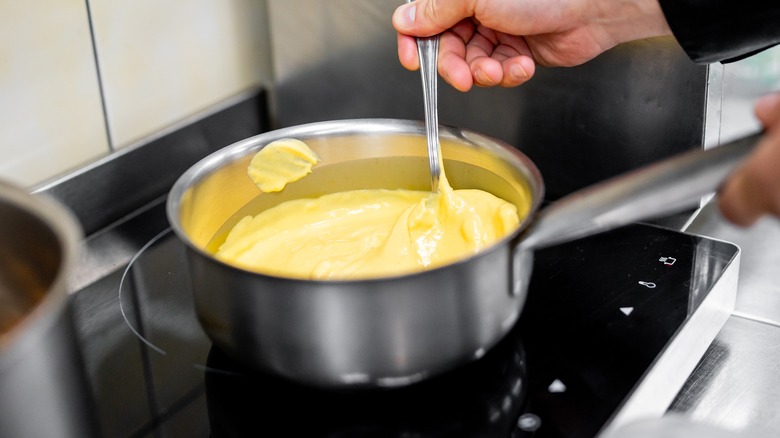 Yellow sauce being stirred on stovetop