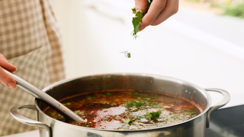 adding spices to soup