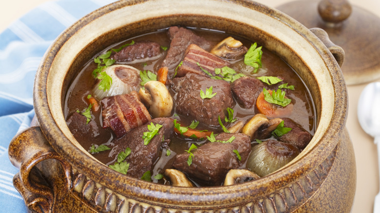 French pot roast in a soup tureen with parsley, mushrooms, and bacon