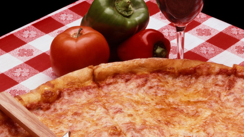 Pizza on table with red and white checked tablecloth