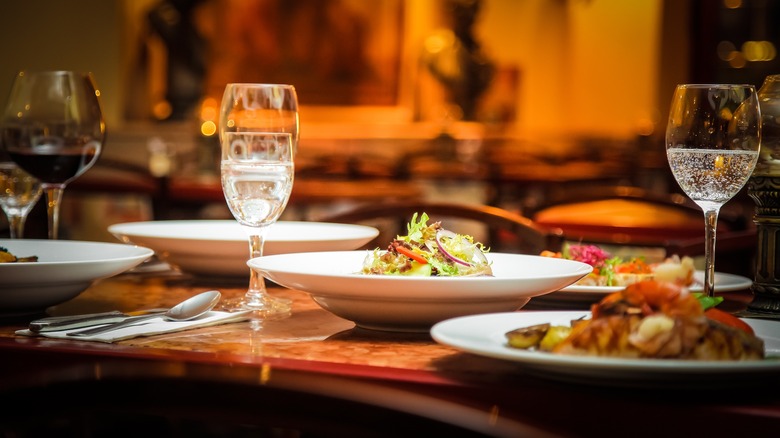 Restaurant table set with glasses and plates of food