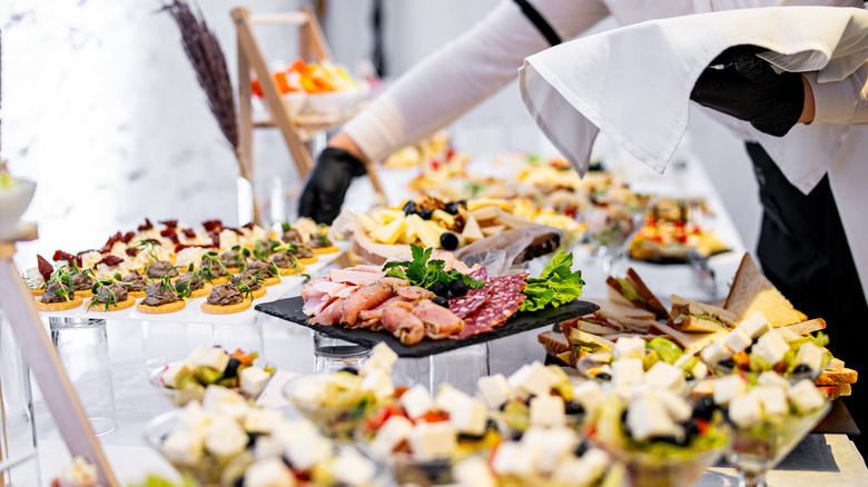 A server with gloves attending to a buffet