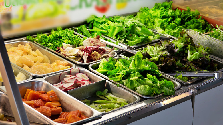 A salad bar with multiple lettuce options