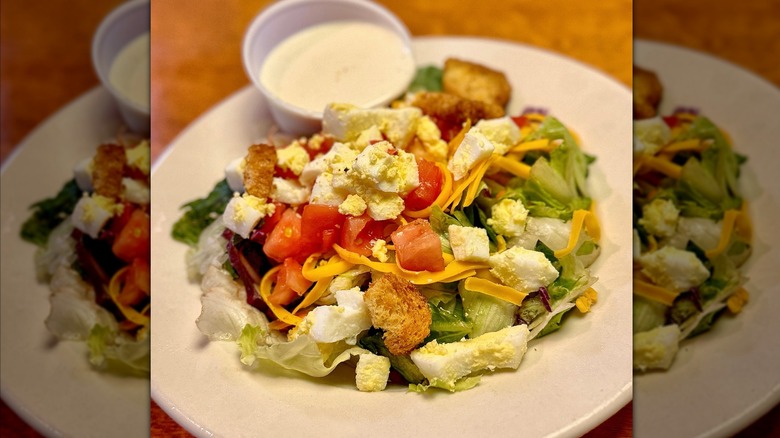 Texas Roadhouse salad on a plate with dressing