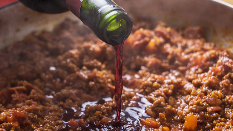 pouring red wine into a pot