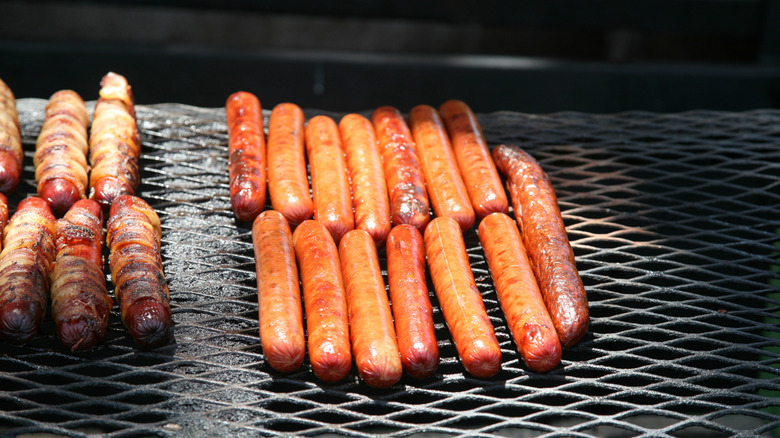 Several hot dogs being cooked on grill