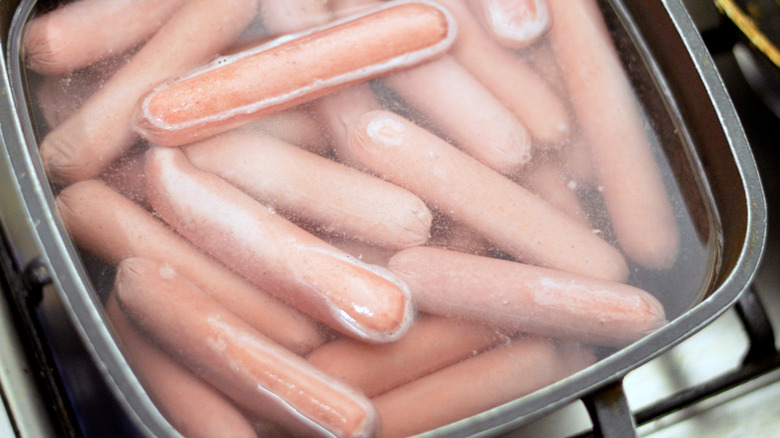 Hot dogs in dish cooking in liquid