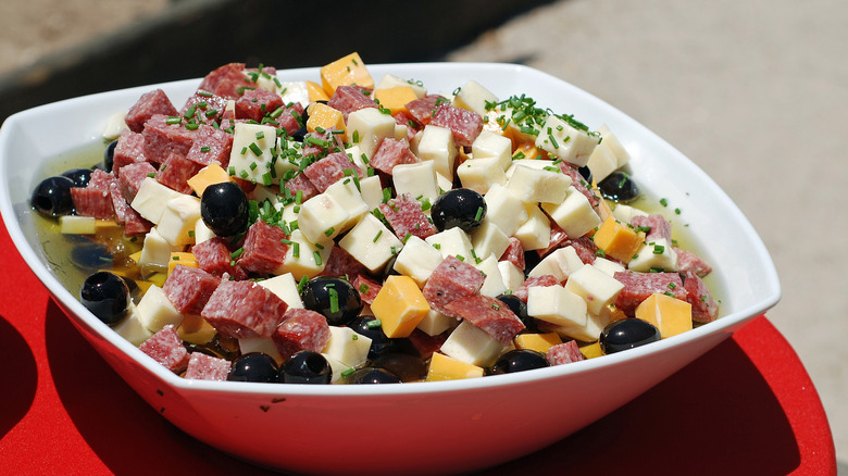 Plated antipasto salad with salami, artichokes, and cheese