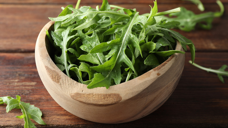 Arugula in a small wooden bowl.