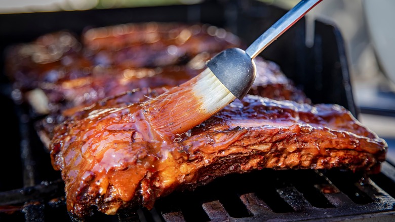 brushing sauce on ribs