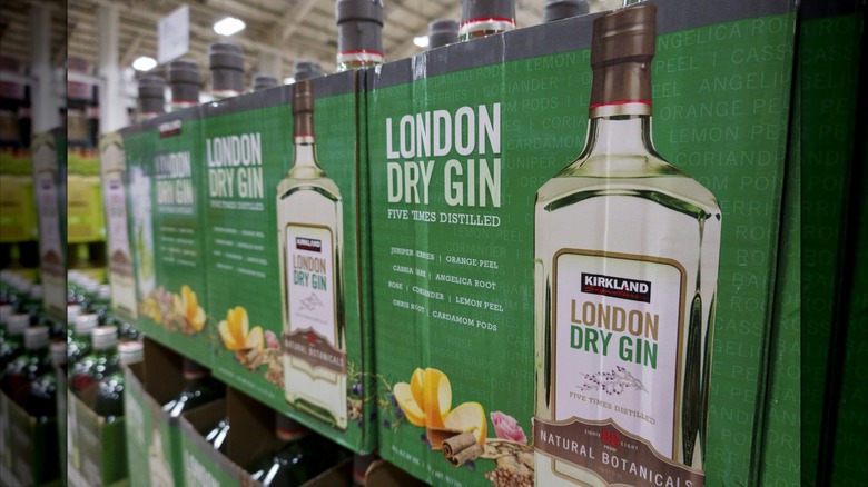 Boxes Kirkland Signature London Dry Gin sit on a shelf in a Costco