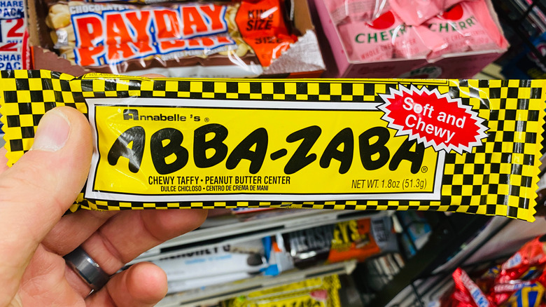 A person holds an Abba-Zaba Bar in a candy aisle