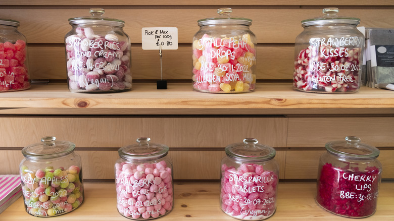 A selection of old fashioned candies are displayed in glass jars