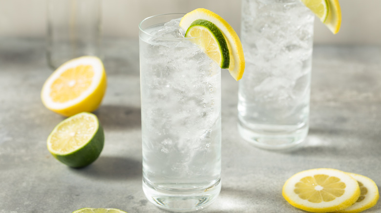 two tall glasses of lemon-lime soda garnished with fresh slices of lemon and lime