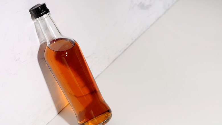 a cocktail made with dark rum and lime in a rocks glass
