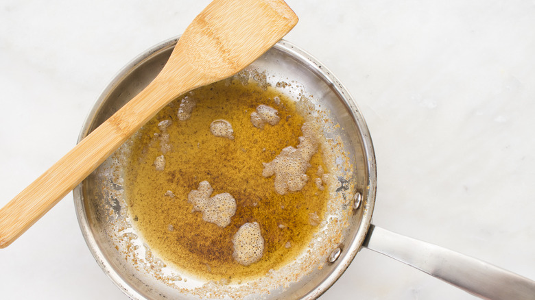 brown butter in pan with wooden utensil