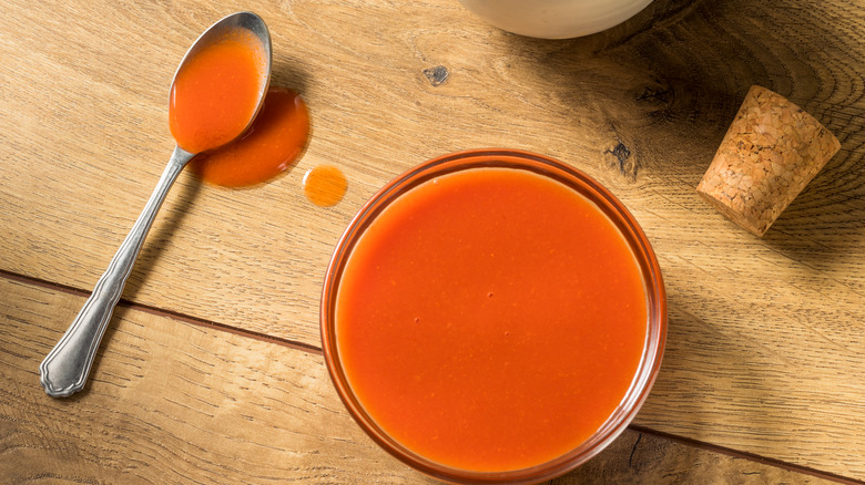 buffalo sauce in bowl with spoon and cork