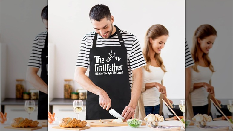 A cook wearing an apron with the words The Grillfather