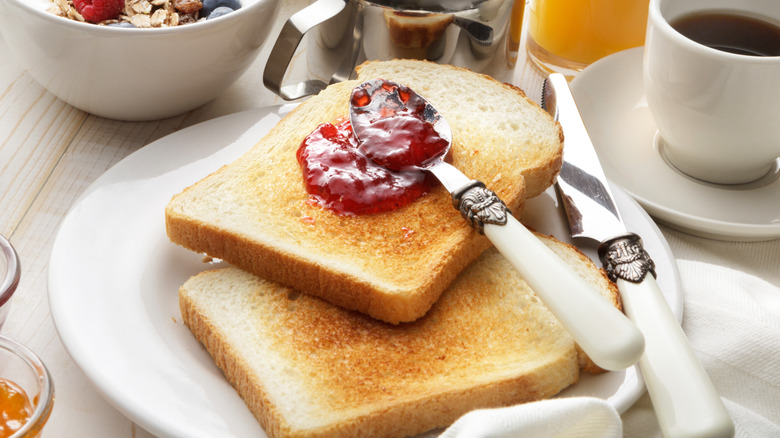 two slices of toast on a plate with a spoonful of jelly on top