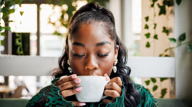 Person drinking a cup of coffee