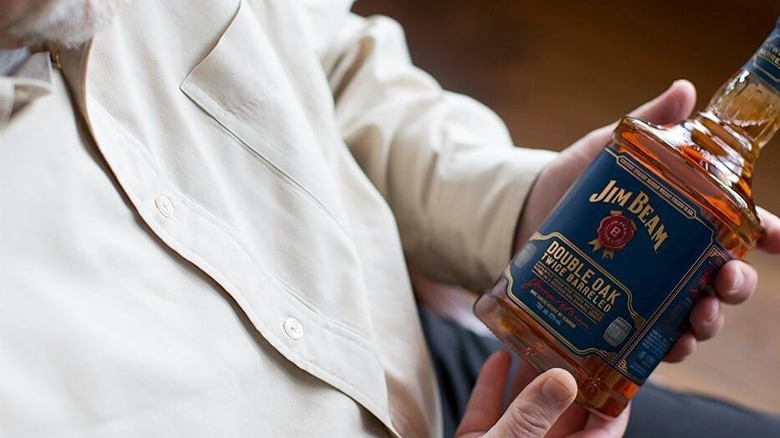 man holding jim beam bottle
